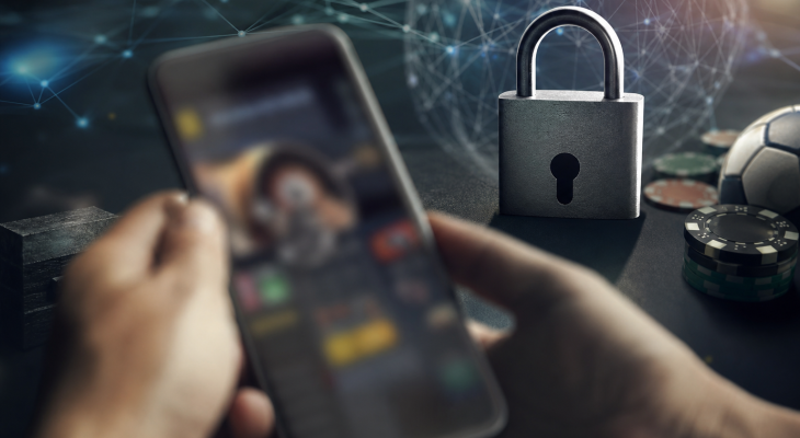 Celular com símbolo visual de bloqueio sobre ambiente digital relacionado a apostas online