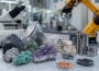 Amostras de minerais estratégicos sobre uma bancada de laboratório, com equipamentos industriais desfocados ao fundo
