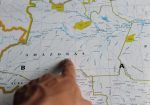 Mão apontando para o estado do Amazonas em um mapa detalhado do Brasil