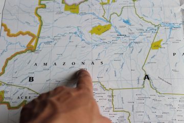 Mão apontando para o estado do Amazonas em um mapa detalhado do Brasil